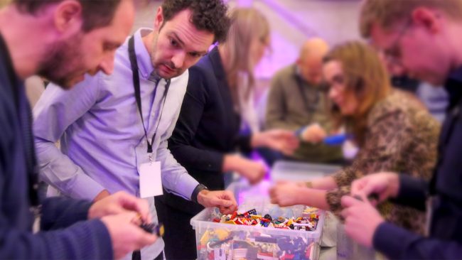 Deelnemers tijdens een evenement met diverse kratten LEGO® bouwstenen