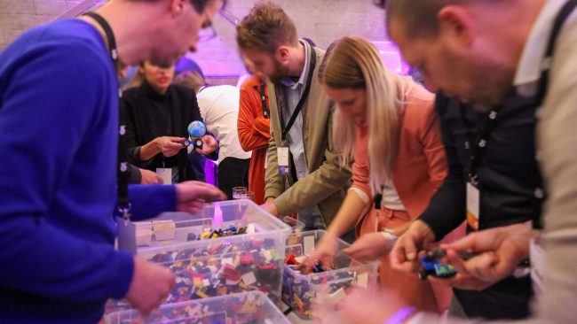 Deelnemers tijdens een evenement met diverse kratten LEGO® bouwstenen