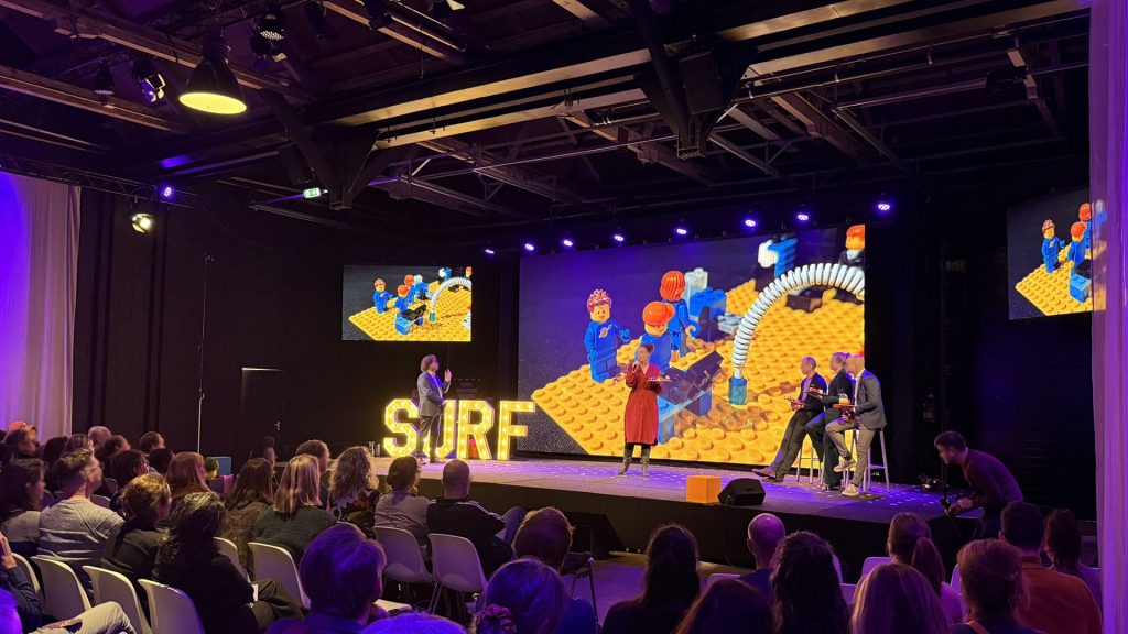 Vier nieuwe directeuren die zichzelf introduceren aan de van een LEGO® bouwwerk tijdens een experience van THE POWER OF BRICKS